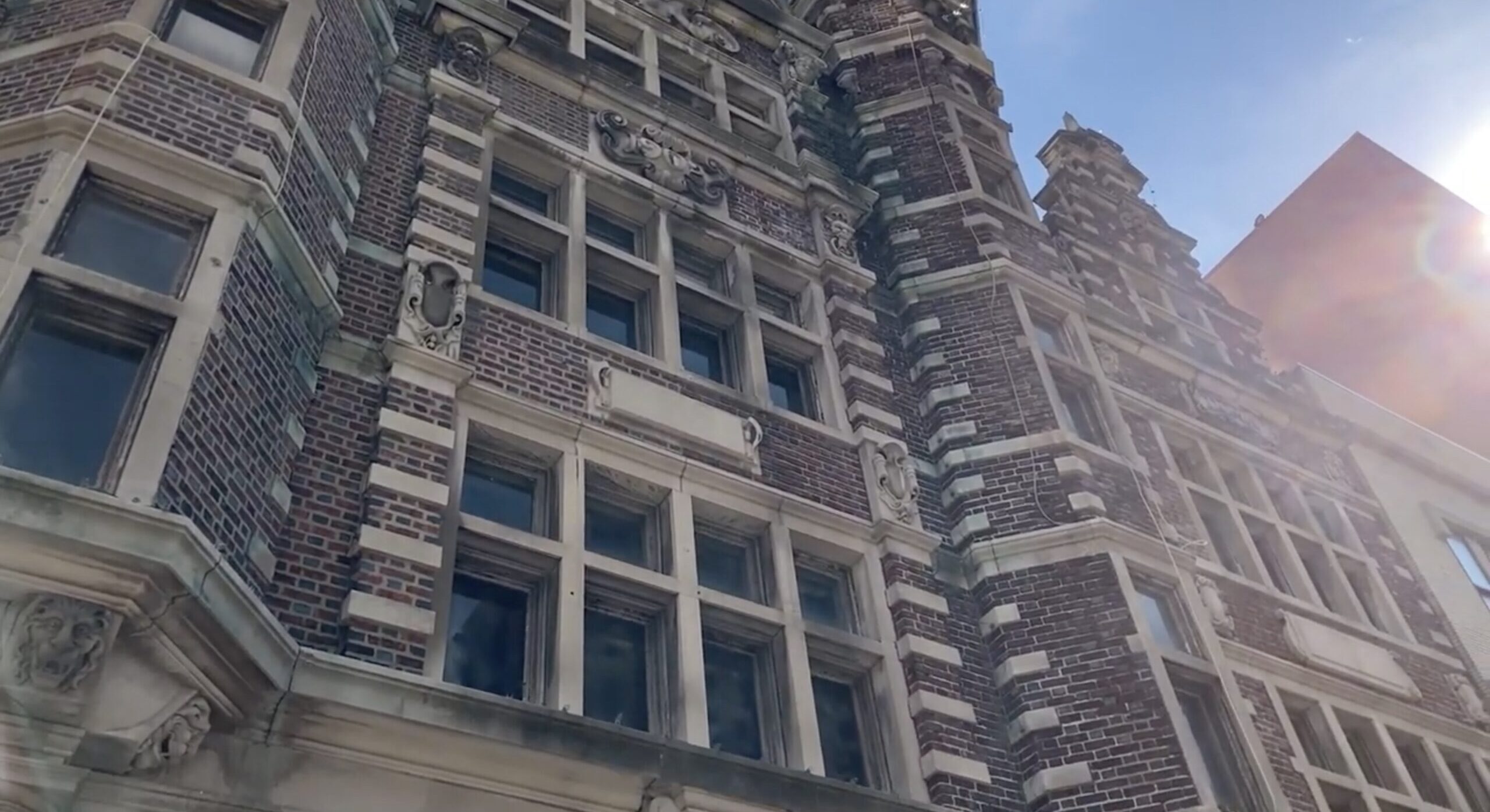 A shot of the Arcade's 3rd street Facade from a low angle. Sunlight fills the right edge of the frame, peeking between neighboring buildings.