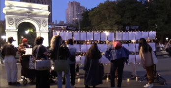 A crowd looking at The Strangers Project installation at Washington Square Park