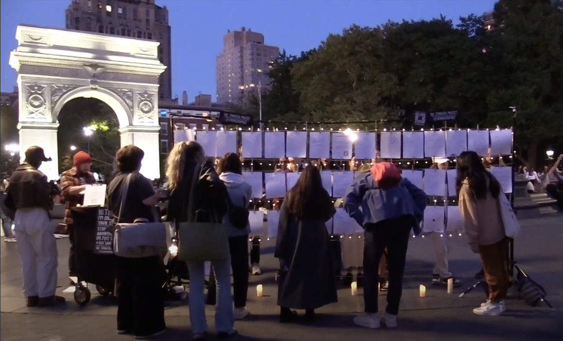 A crowd looking at The Strangers Project installation at Washington Square Park