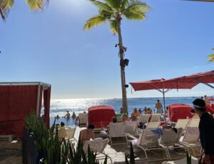 Tourists on lounge chairs on a sunny beach in Ala Moana, Hawaii