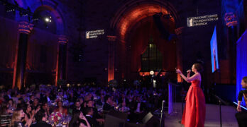 Woman in a red gown addressing a crowd at the Endometriosis Foundation of America's 11th Annual Blossom Ball. Image by Bryan Bedder/Getty Images