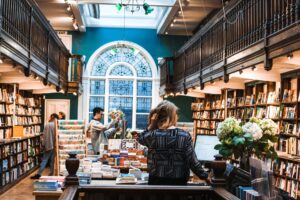 People browsing bookshelves in a brightly lit library