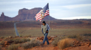 Brandon Nez displays his flag at near his jewelry stand in Monument Valley, Utah.