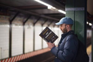 A man reads the book "Lost Connections" while waiting on a New York City subway platform.