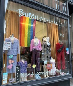 Clothing store display window featuring various multi-colored outfits