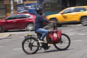 A food delivery worker rides an e-bike in New York City.