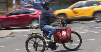 A food delivery worker rides an e-bike in New York City.