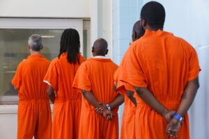 Prisoners line up to vote at the D.C. Jail in Washington. The voters at this southeast Washington polling place were all dressed alike: orange jumpsuit, white shoes. And when they finished voting they went back to their cell block, not back to work. Still, voting inside the D.C. Jail looked a lot like voting at precincts around the country (AP Photo/Jacquelyn Martin)