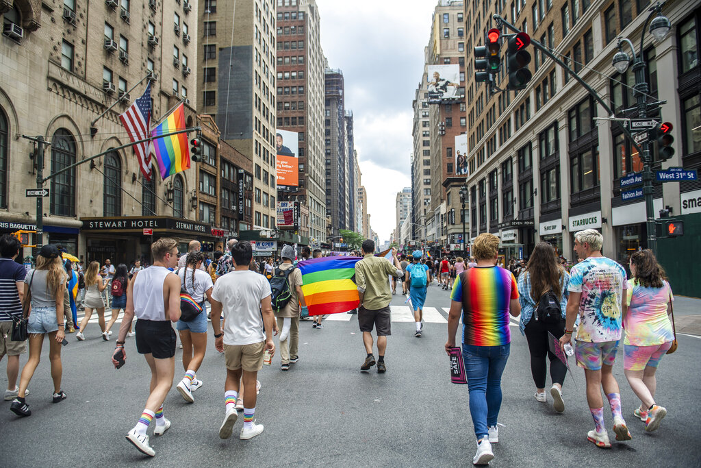 People walk with rainbow flags.