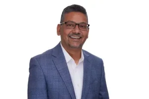 Smiling man with glasses and short hair in business casual attire