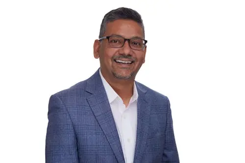 Smiling man with glasses and short hair in business casual attire